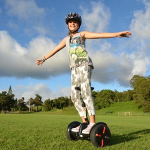 Girl on mini segway arms out