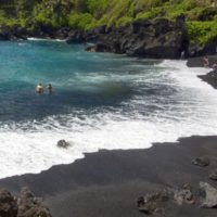 blacksand beach couple in water